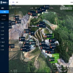 A 3D aerial map displays a quarry site with labeled markers indicating various locations and monitoring points, surrounded by forested areas.