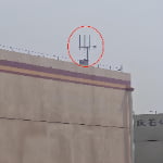 Close-up of multi-pole antenna array mounted on rooftop for TXWG long-distance communication.