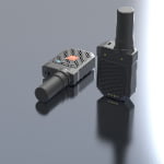 Two compact black walkie-talkie devices with antennas are placed on a reflective surface, one lying down and one standing upright.